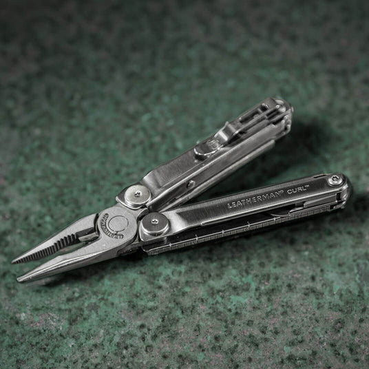 Translation missing: de.A Leatherman Curl laying on a tabletop with pliers and pocket clip showing