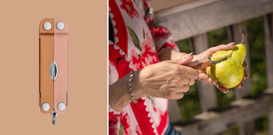 Translation missing: de.A person using the knife on a Ginger Peach Micra® multitool to cut into a pear, showcasing a stylish design and practical functionality