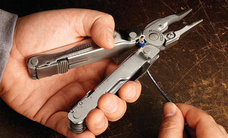 Translation missing: de.Man using Leatherman Super Tool 300 to strip wire