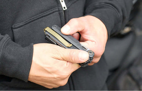 Translation missing: de.Person holding an Obsidian Leatherman Wave® Alpha multi-tool, showcasing the Brass PVD Quick-Release pocket clip