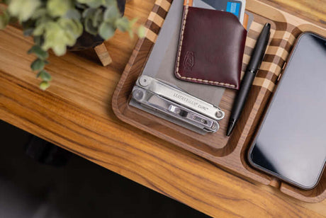 Translation missing: de.A Leatherman Curl closed laying on a tray next to a wallet and pen