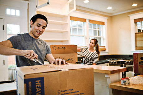 Translation missing: de.Man using a Leatherman to open a moving box