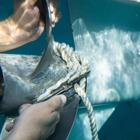Translation missing: de.Leatherman ARC cutting rope wrapped around boat propeller under water. 