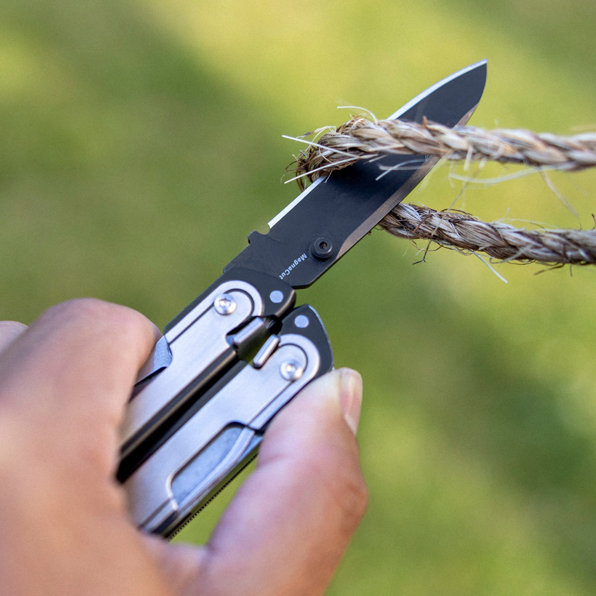 Translation missing: de.Person using one hand to open a Black DLC and stainless steel Leatherman ARC® multitool
