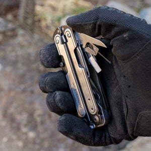 Translation missing: de.Black DLC &amp; Stainless Steel Leatherman ARC® held in a gloved hand, showcasing some tool included tools