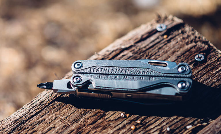 Translation missing: de.Leatherman Charge+ TTI laying on piece of wood under sunlight