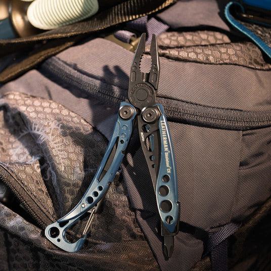Translation missing: nl.Nocturnal Leatherman Skeletool® Cx multi-tool displayed on a backpack, showcasing its sleek design and functionality