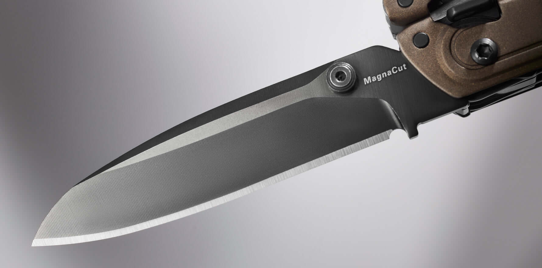 Close-up of a knife blade in MagnaCut steel, demonstrating sharpness and precision, ideal for outdoor enthusiasts.