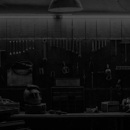 Translation missing: de.A dimly lit workshop with various tools hanging on the wall, a workbench, and storage drawers