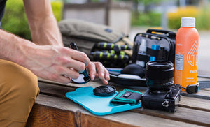 Translation missing: de.Man using Leatherman® Adapt Kit tray to clean camera lens