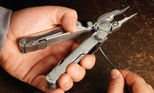 Translation missing: de.Man using Leatherman Super Tool 300 to strip wire